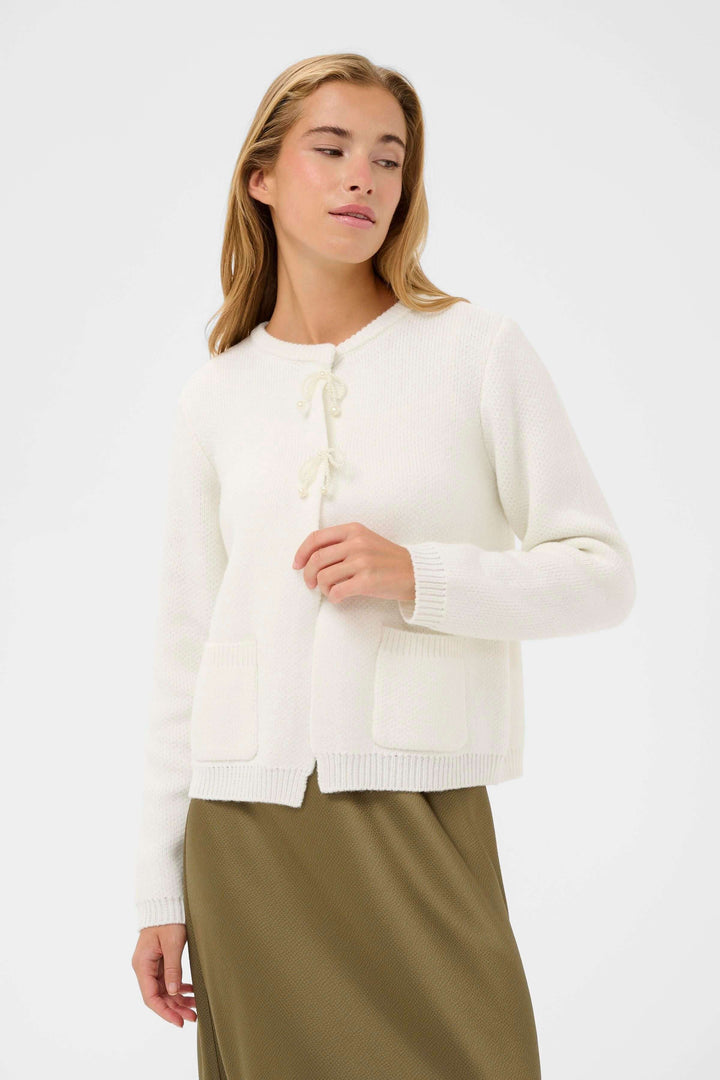 Femme portant Cardigan Bowie blanc avec liens décoratifs, idéale pour un look élégant et confortable, coupe droite et encolure arrondie.