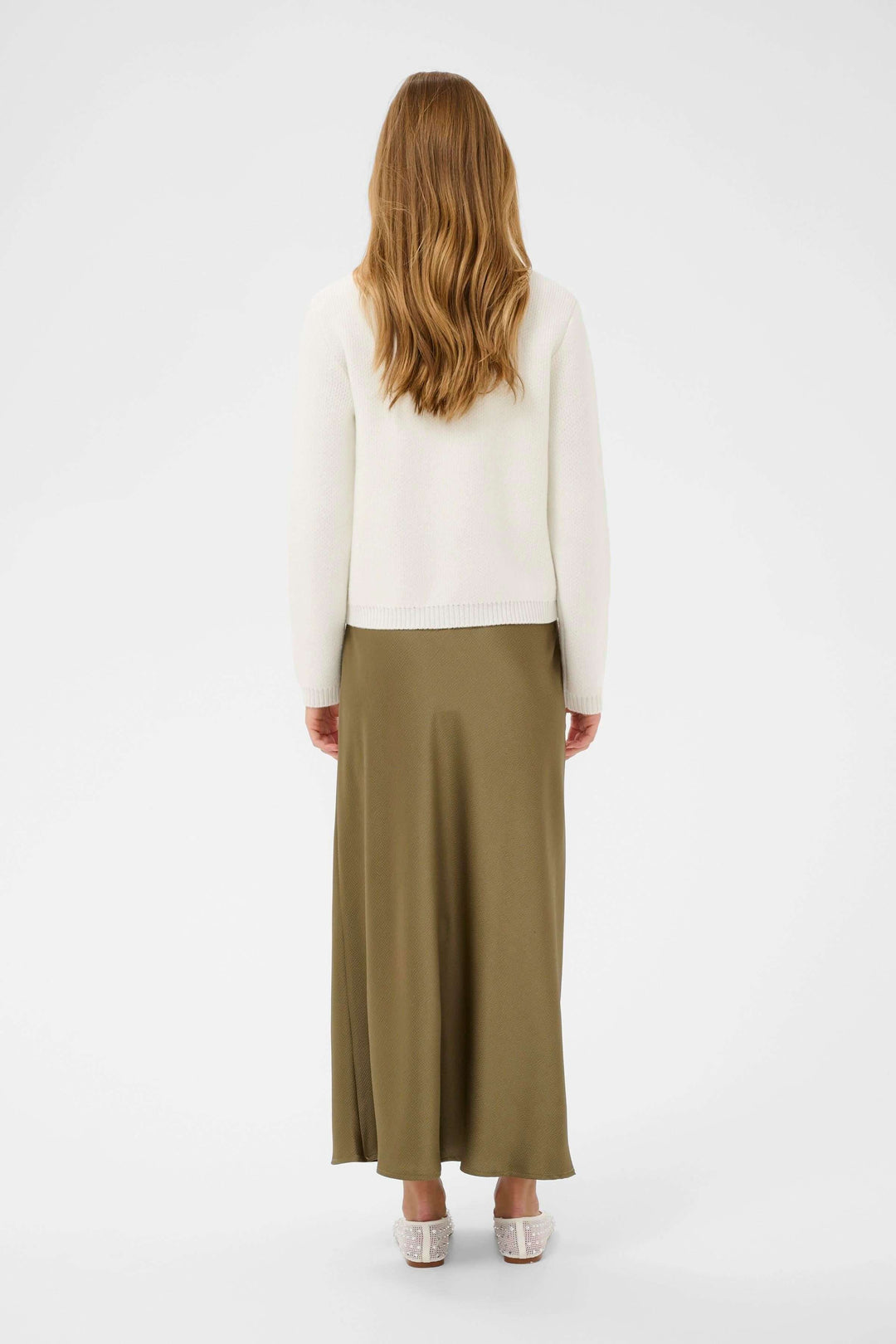 Vue arrière d'une femme portant le Cardigan Bowie avec une jupe longue, montrant un style élégant et intemporel.