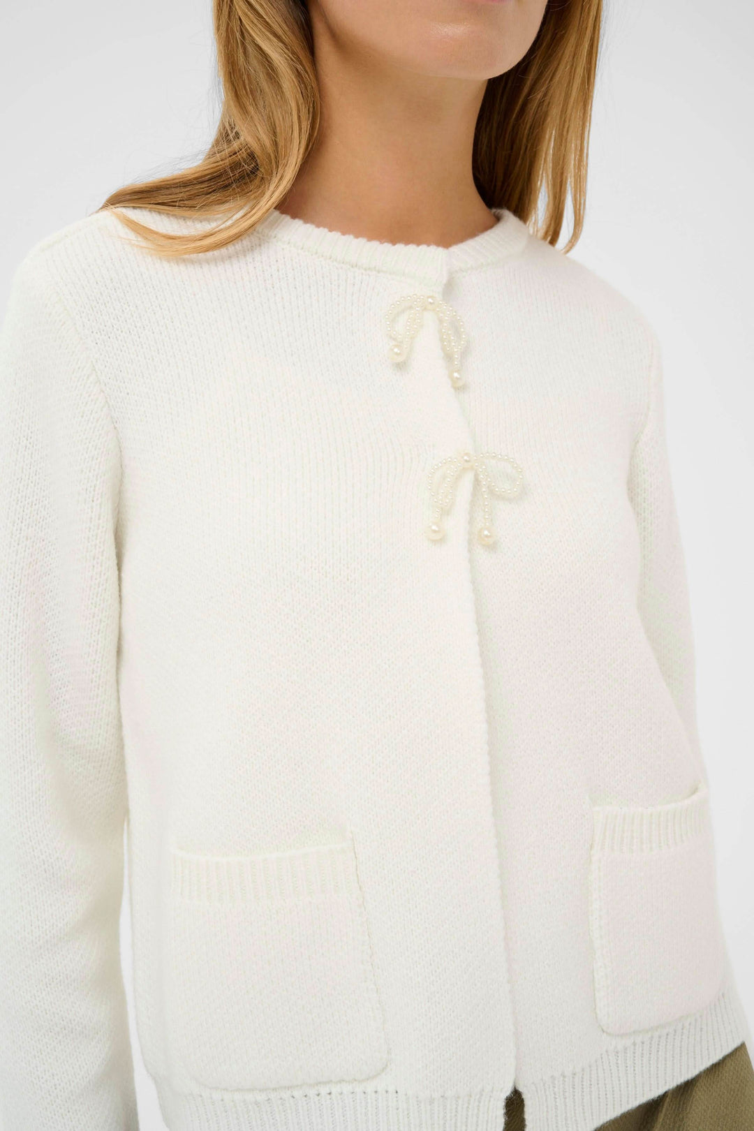 Cardigan Bowie blanc avec décorations féminines sur le devant, style élégant et coupe droite, encolure arrondie pour confort quotidien.