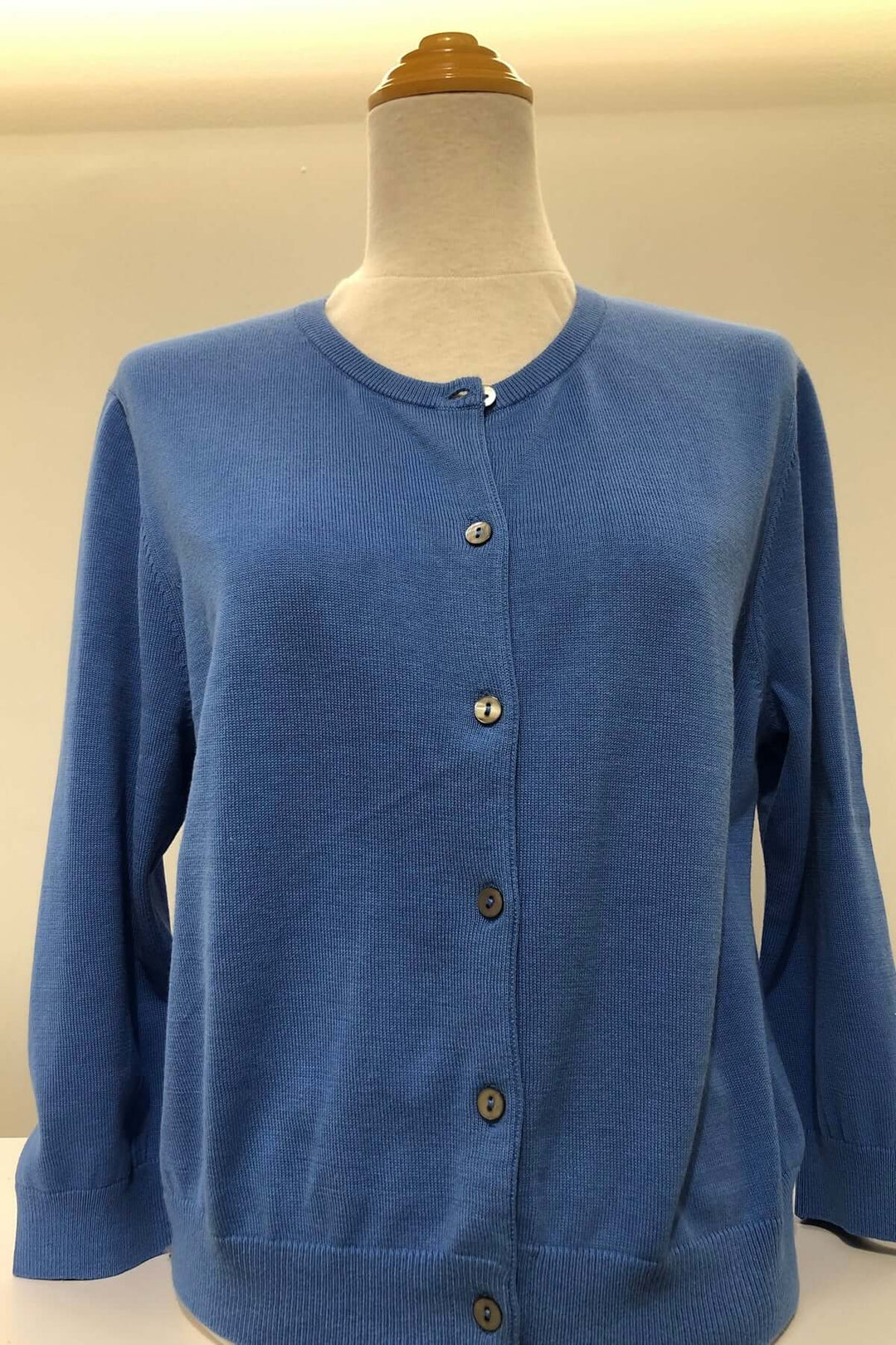 Cardigan court bleu avec encolure ronde, manches longues et patte de boutonnage, parfait pour les temps frais.