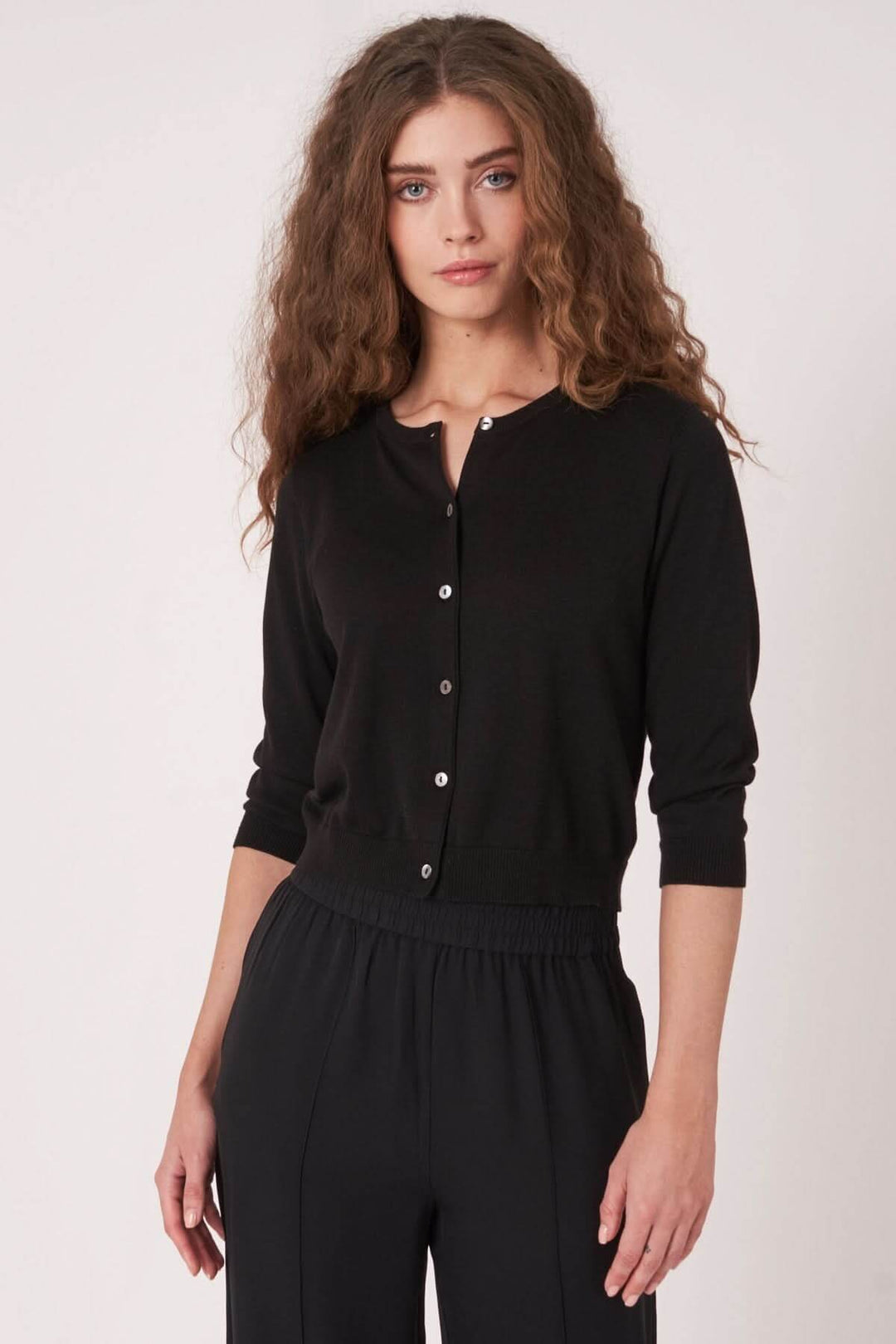 Cardigan noir court à encolure ronde et boutons, parfait pour les tenues de mi-saison.