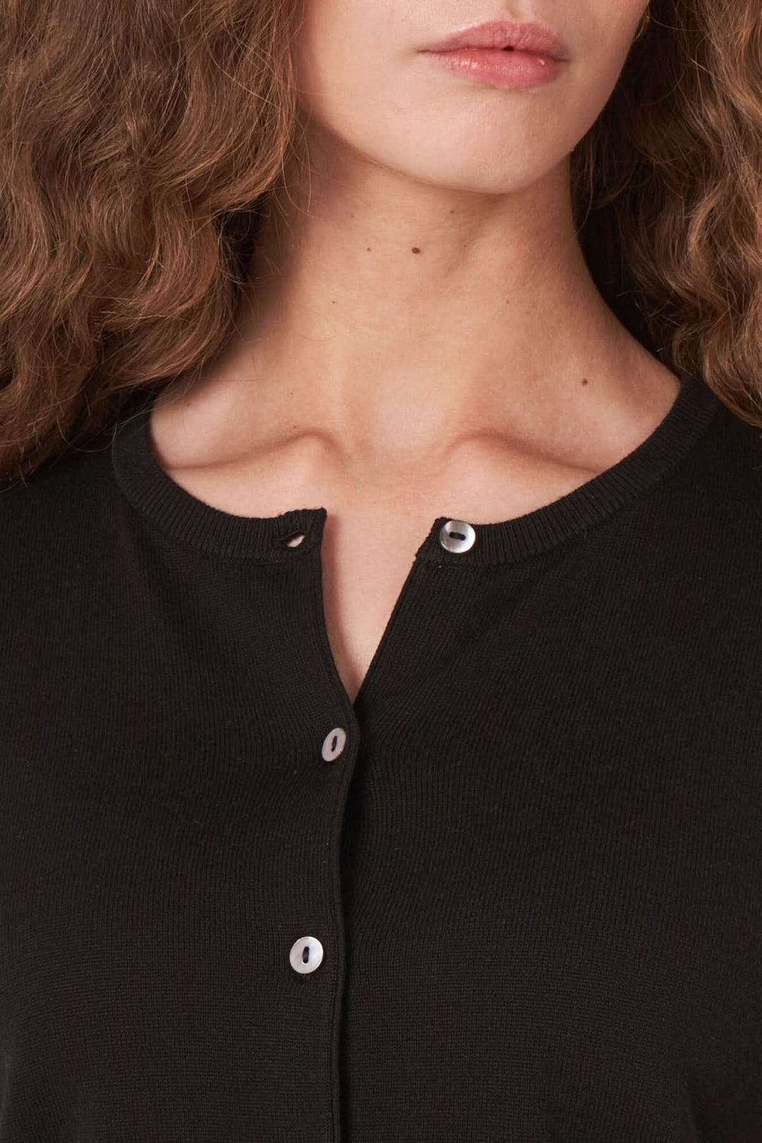 Cardigan noir près du corps avec encolure ronde et boutons élégants, idéal pour les temps frais.
