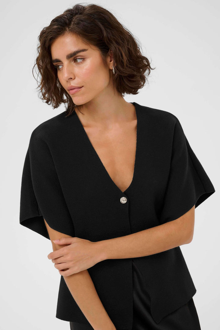 Cardigan Jessica avec design moderne, coupe évasée et encolure en V, porté par un modèle. Confort optimal et élégance raffinée.