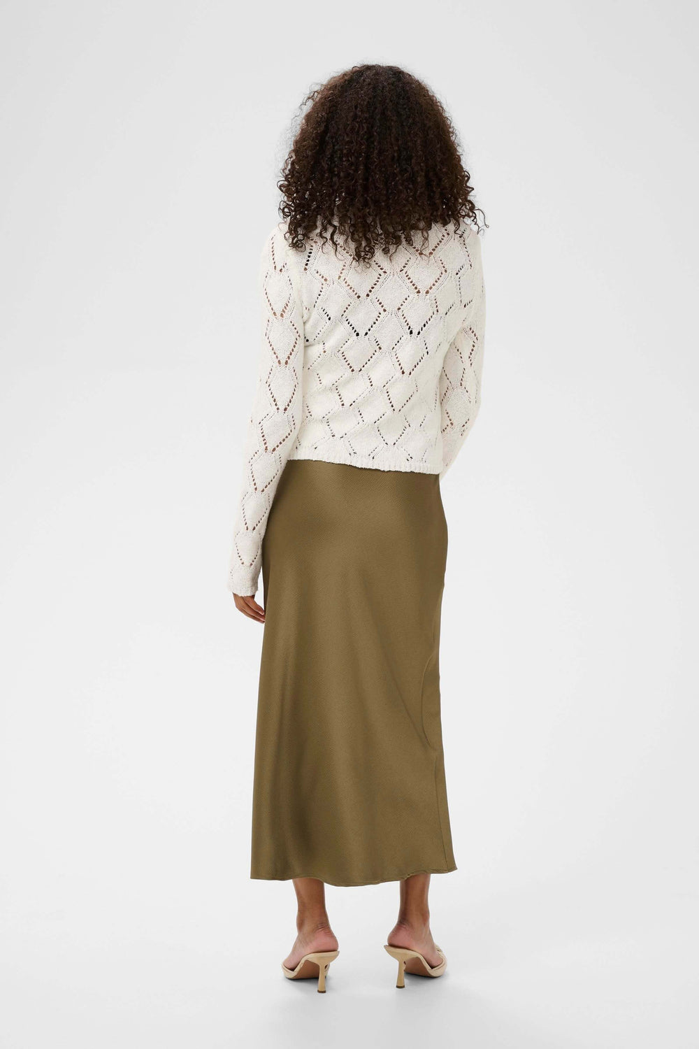 Femme portant le Cardigan Lorinia en maille ajourée, vue de dos, élégant et décontracté, idéal pour une tenue soignée au quotidien.