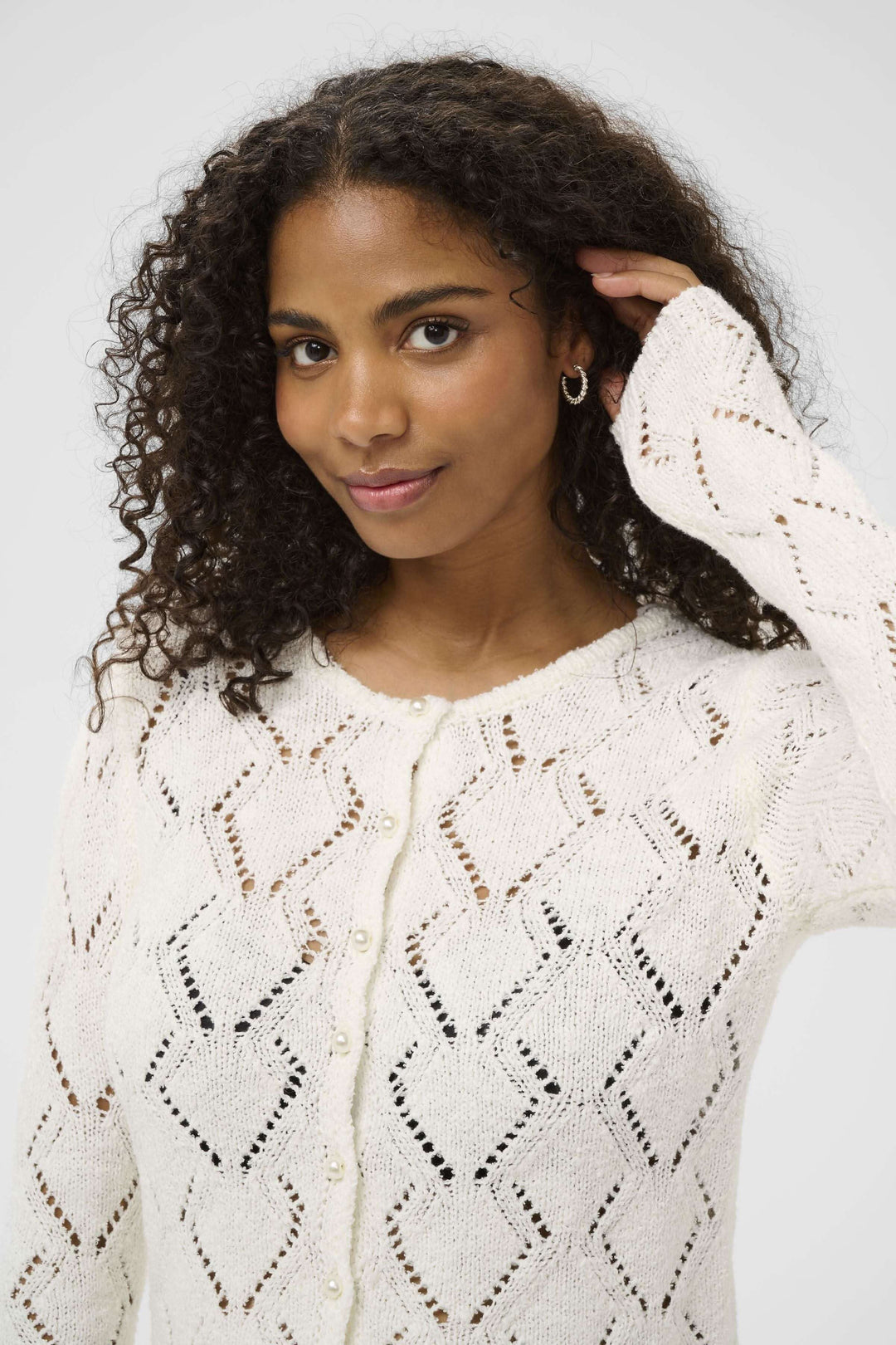 Cardigan Lorinia en maille ajourée, élégant et féminin, porté par une femme. Parfait pour un style soigné ou décontracté.