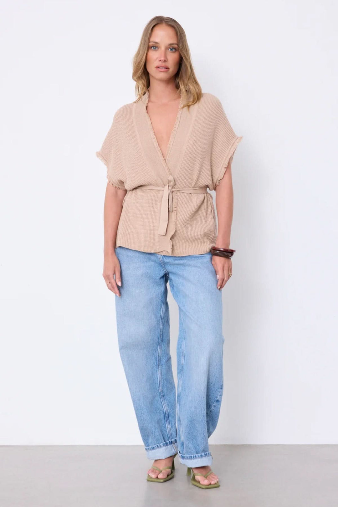 Femme portant le Cardigan Sonya texturé ceinturé manches courtes avec col en V, texture gaufrée, et ceinture à nouer, coupe ample.