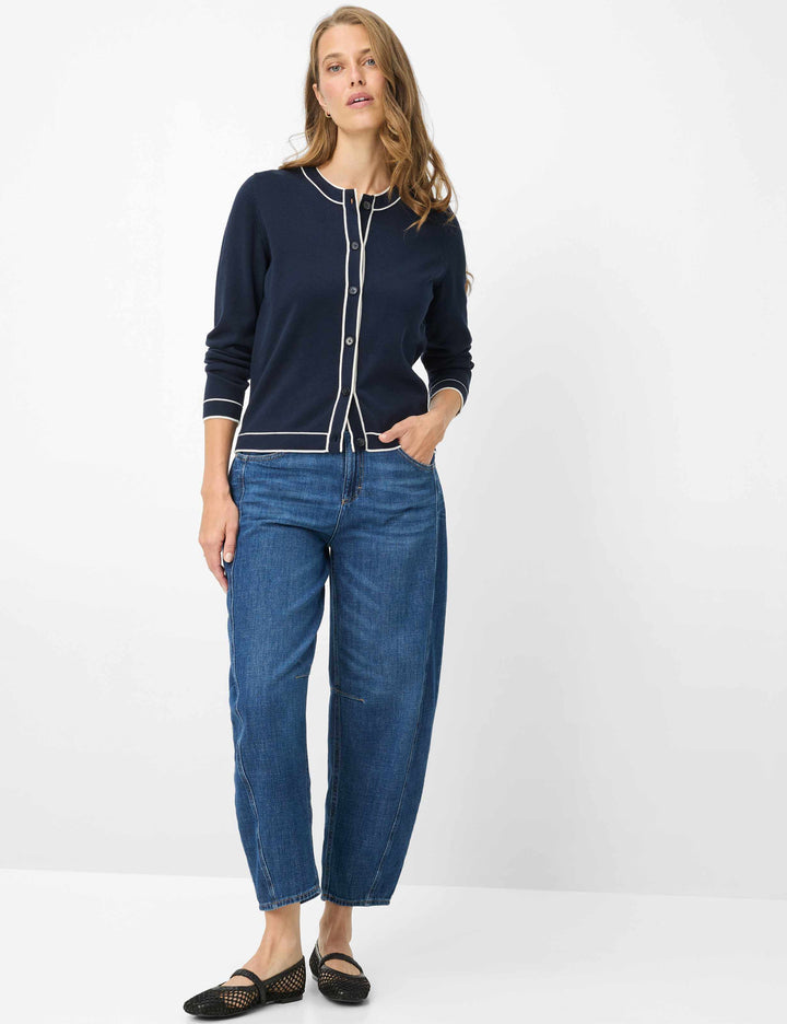 Femme portant un cardigan boutonné à col contrasté ANN avec une tenue décontractée, mettant en avant le style et l'élégance du vêtement.