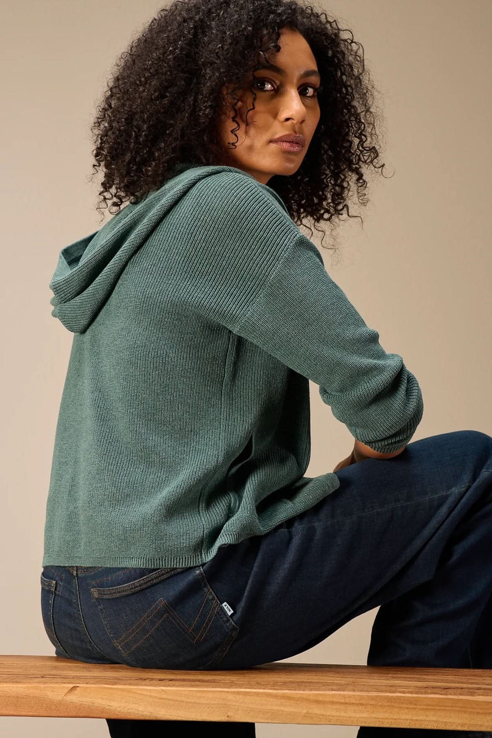 Femme portant un cardigan à capuche en maille, style décontracté et moderne, idéal pour le quotidien, avec manches longues et boutonnière.
