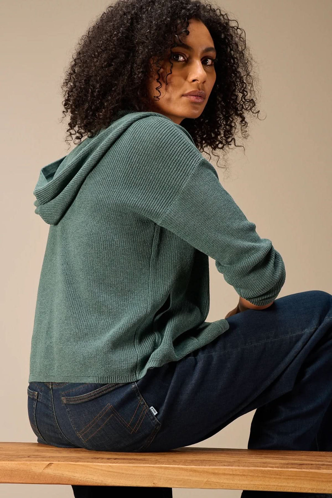 Femme portant un cardigan à capuche en maille, style décontracté et moderne, idéal pour le quotidien, avec manches longues et boutonnière.