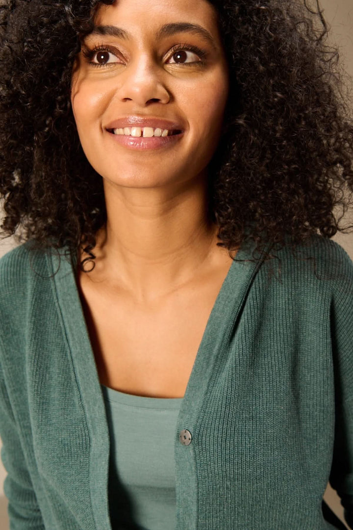 Cardigan à capuche en maille vert avec capuche intégrée, style décontracté pour femme, porté pour un look casual et moderne.