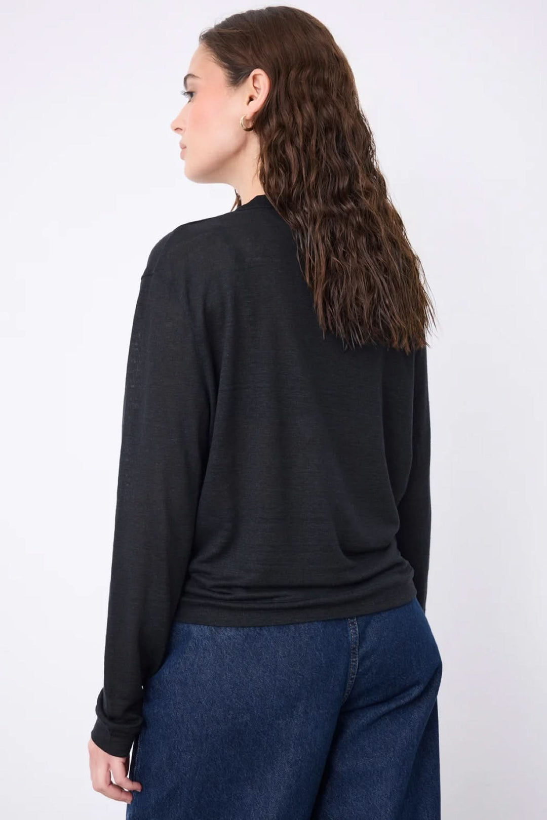 Vue arrière du cardigan col v boutonné léger en maille noire, porté avec un jean. Silhouette décontractée et féminine.