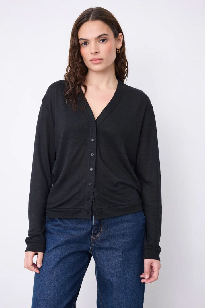 Cardigan col v boutonné léger en noir porté par une femme