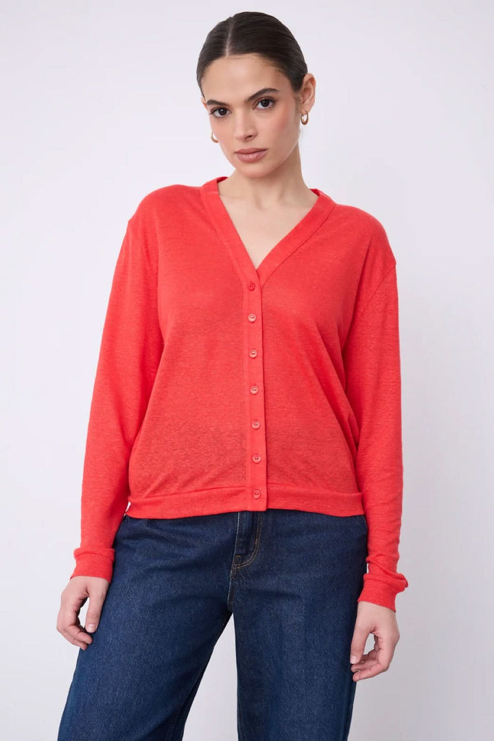 Femme portant un cardigan col v boutonné léger rouge avec un jean.