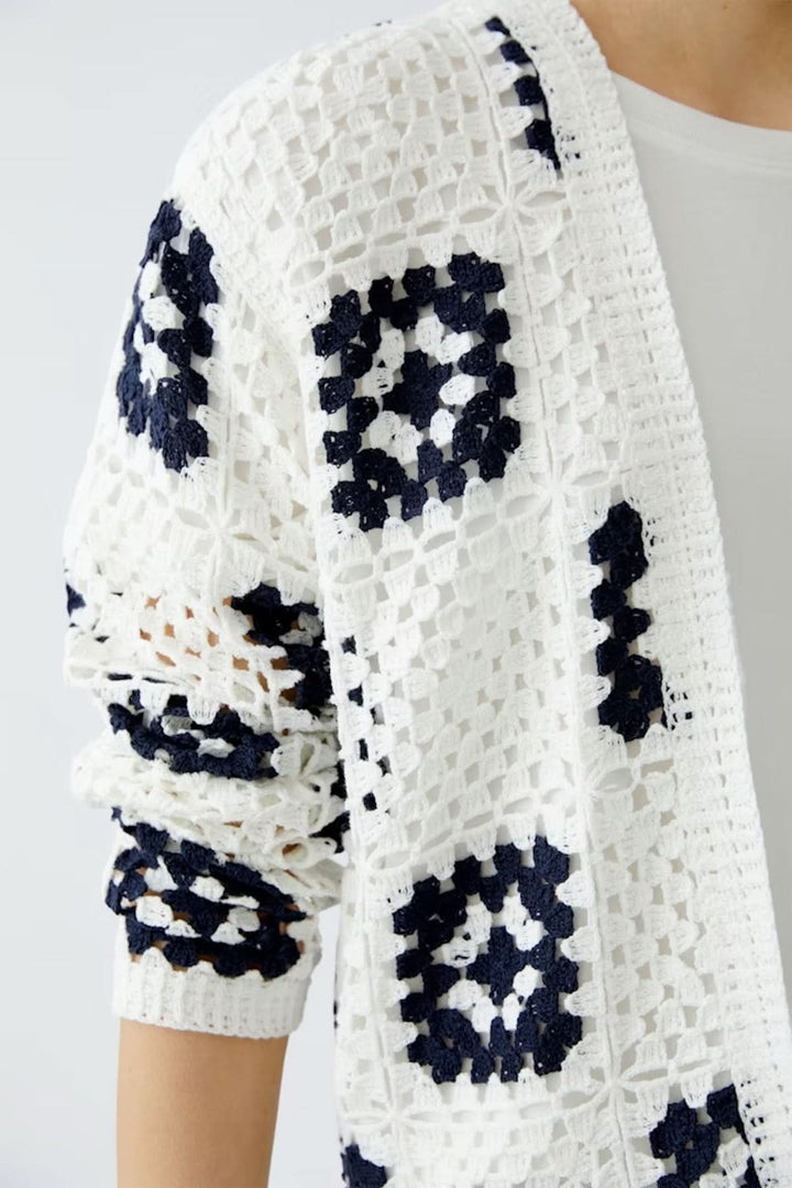 Cardigan en crochet blanc avec motifs géométriques marines, parfait pour un look bohème et décontracté.