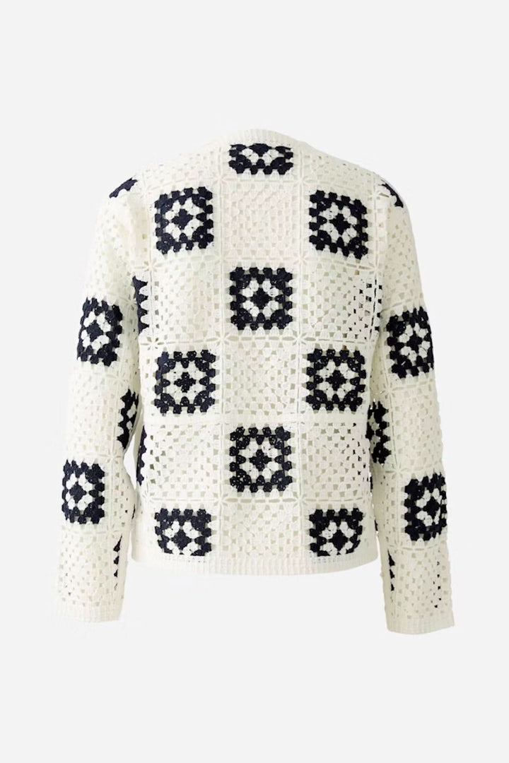 Cardigan en crochet blanc avec motifs géométriques noirs, vue arrière, style bohème décontracté.