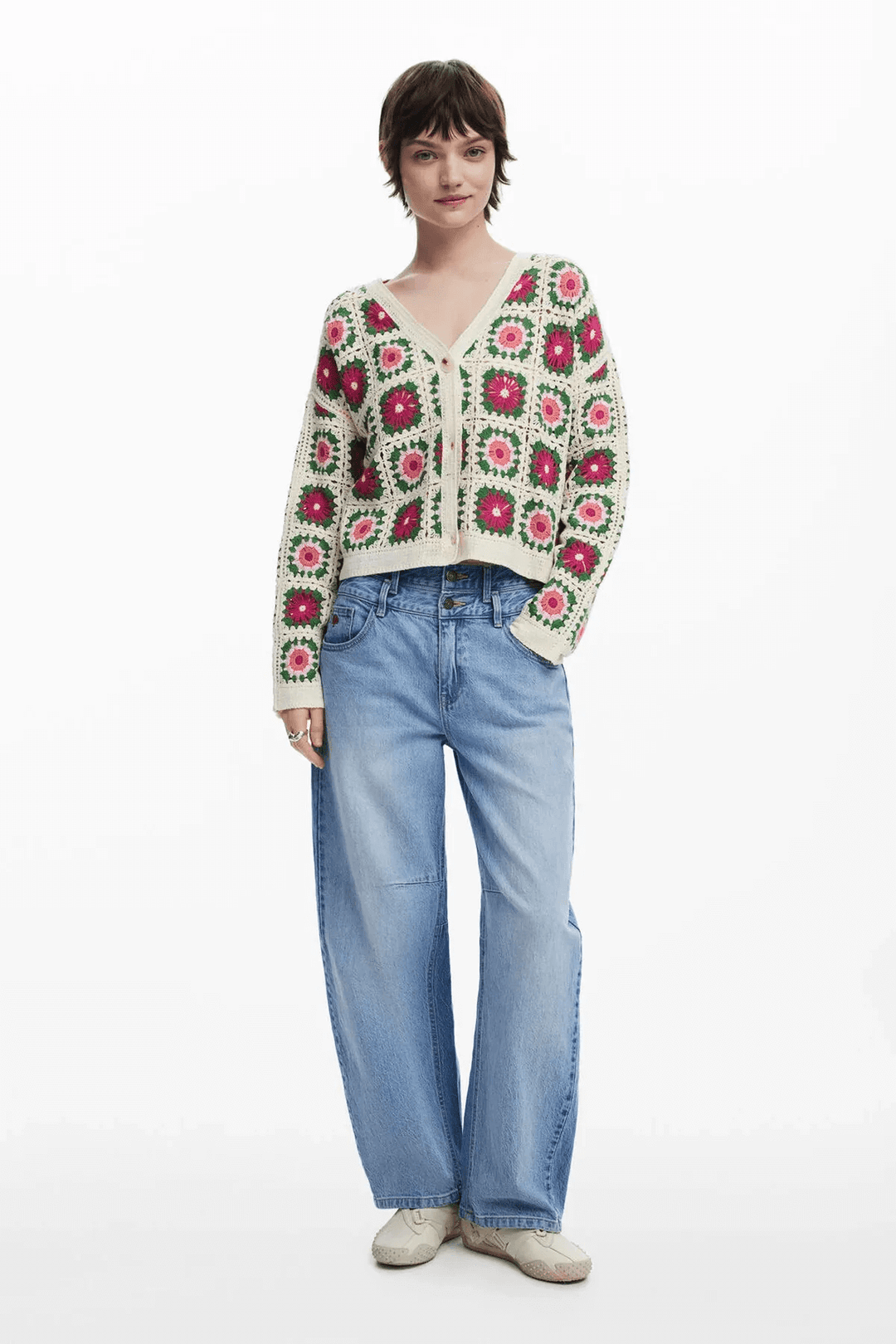 Femme portant un cardigan en crochet à motif floral coloré, col en V, associé à un jean large.