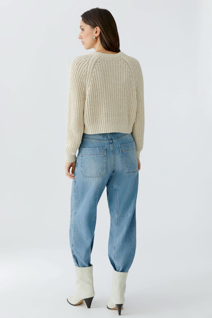 Vue arrière du Cardigan en maille boutonné, manches longues, texture tricotée, sur modèle avec jean bleu et bottes blanches.