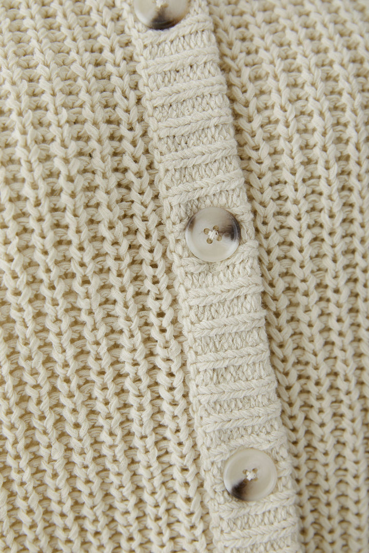 Cardigan en maille boutonné avec texture tricotée et boutons détaillés sur le devant, style moderne et polyvalent.