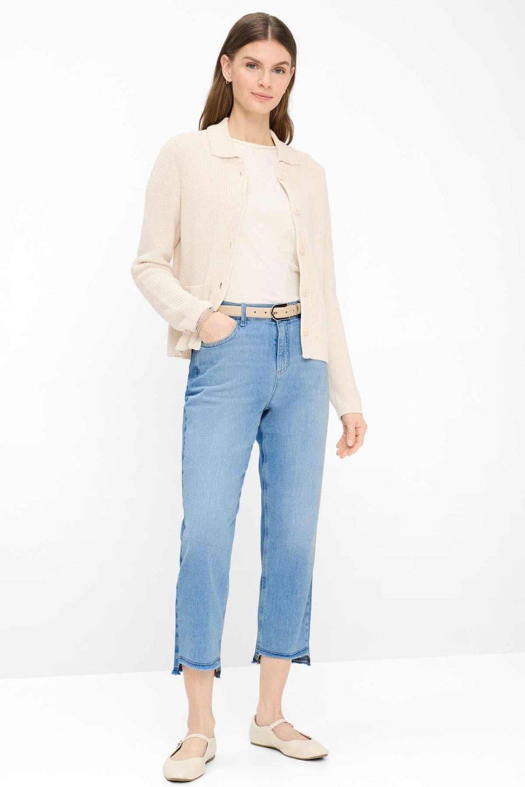 Femme portant un cardigan en maille côtelée AMI avec col chemise, coupe droite, sur un t-shirt, style classique et épuré.