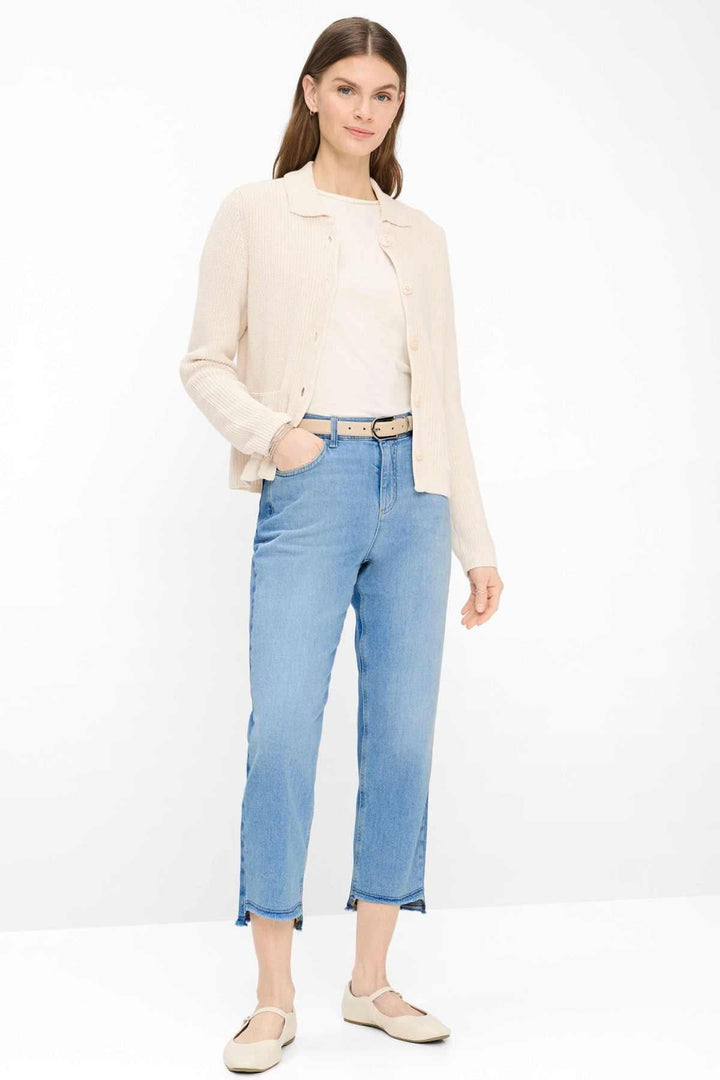 Femme portant un cardigan en maille côtelée AMI avec col chemise, coupe droite, sur un t-shirt, style classique et épuré.