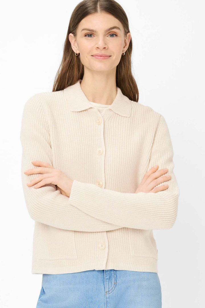 Femme portant un Cardigan en maille côtelée AMI beige avec col chemise et fermeture boutonnée, tenue décontractée et élégante.