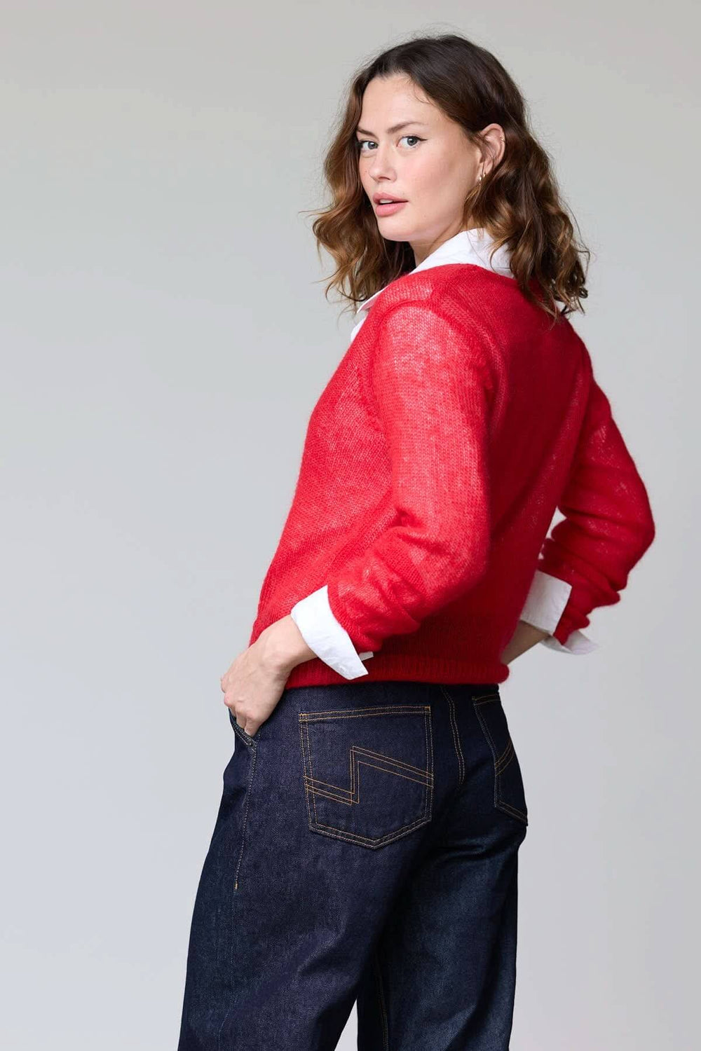 Cardigan en mohair léger rouge avec encolure en V et finition côtelée, porté par-dessus chemise blanche, vue arrière.