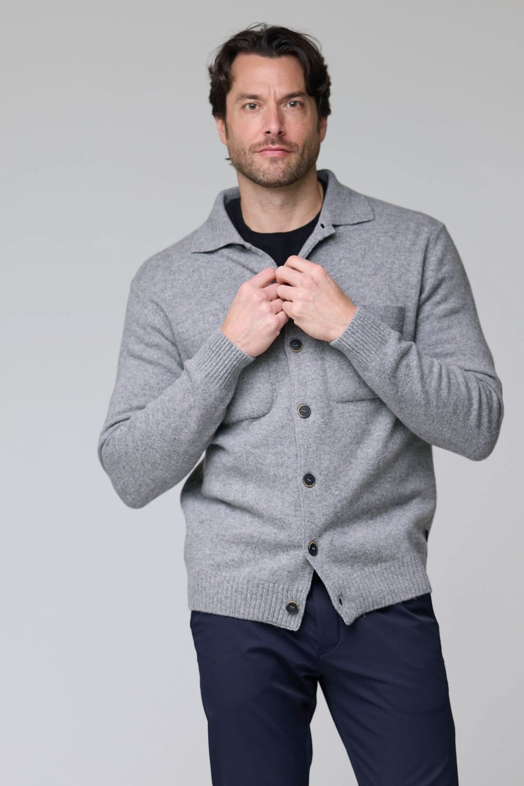 Homme portant un Cardigan à poches plaquées en laine gris avec boutons contrastants et deux poches plaquées.