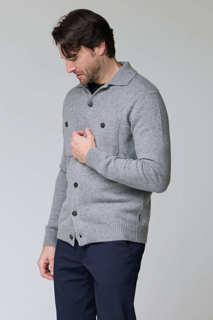 Cardigan à poches plaquées en laine gris avec boutons contrastants porté par un homme