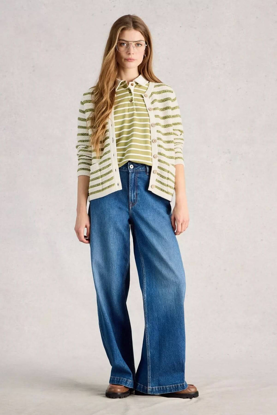Femme portant un cardigan rayé boutonné avec un jean large, idéale pour un look casual et confortable.