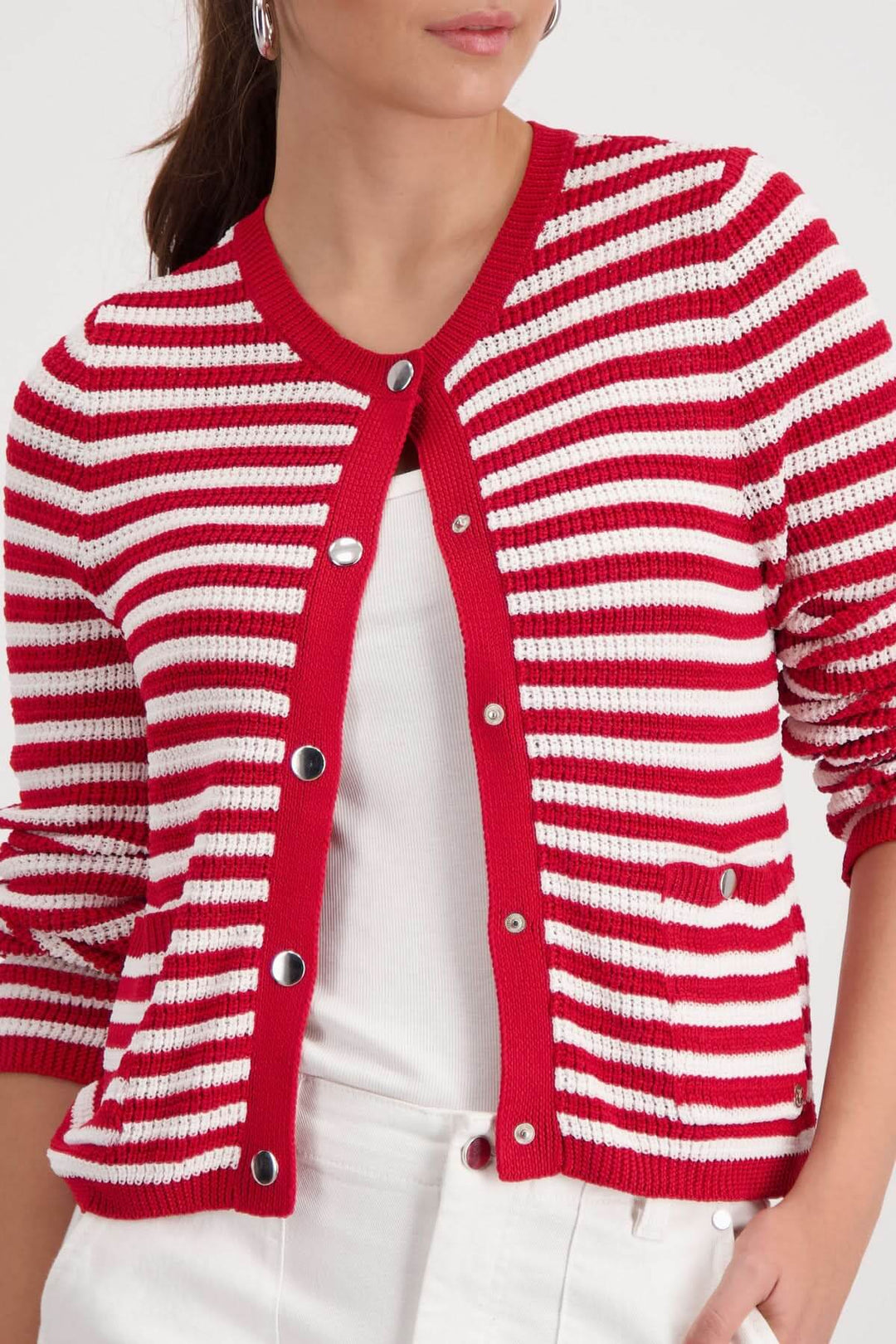 Cardigan rayé boutonné rouge et blanc, encolure arrondie, style structuré féminin, porté sur un haut blanc.