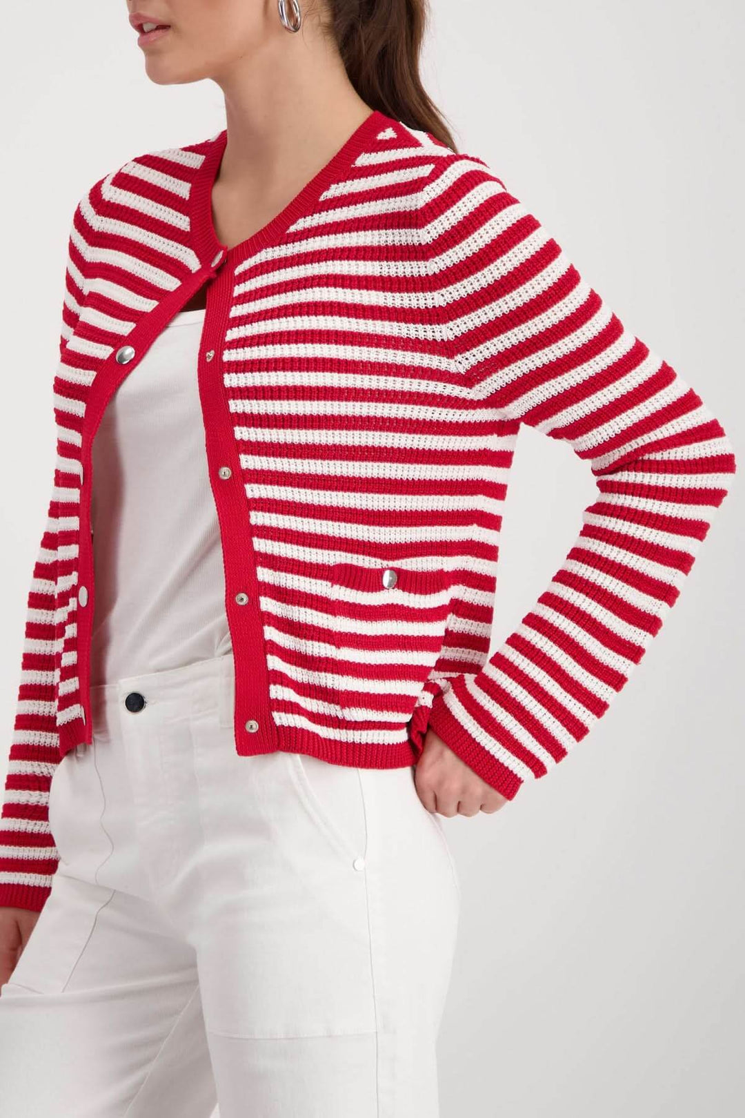 Femme portant un cardigan rayé boutonné rouge et blanc, coupe droite avec encolure arrondie, style décontracté et structuré.