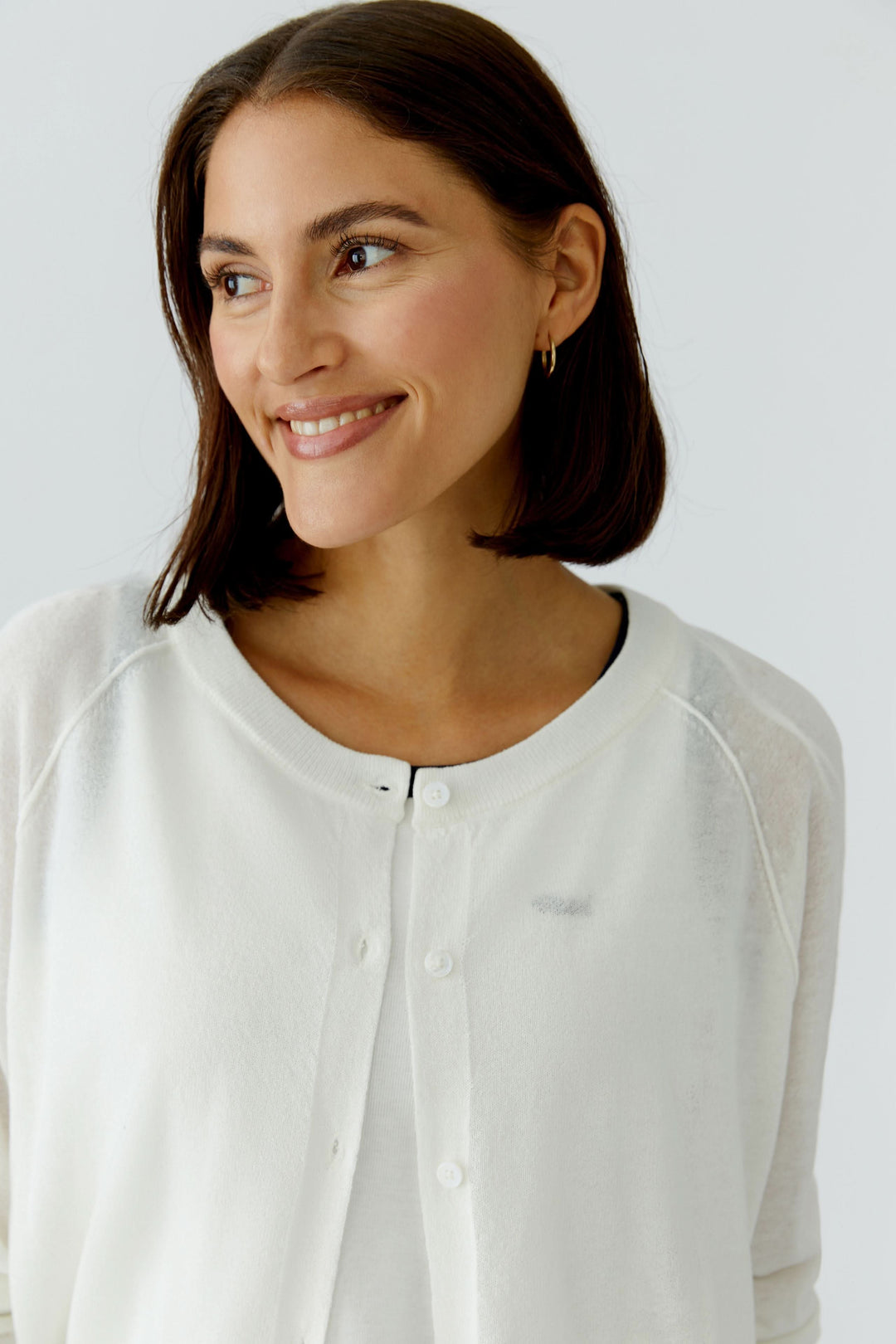 Femme portant un cardigan texturé boutonné élégant à encolure arrondie et texture subtile en relief, style polyvalent.