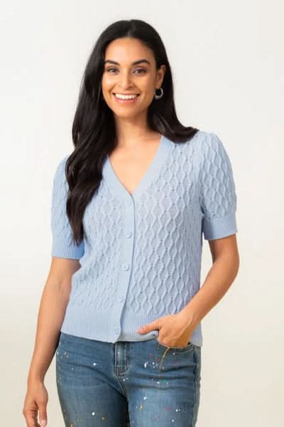 Cardigan tressé bleu clair avec encolure en V et manches 1/2, porté avec un jean.