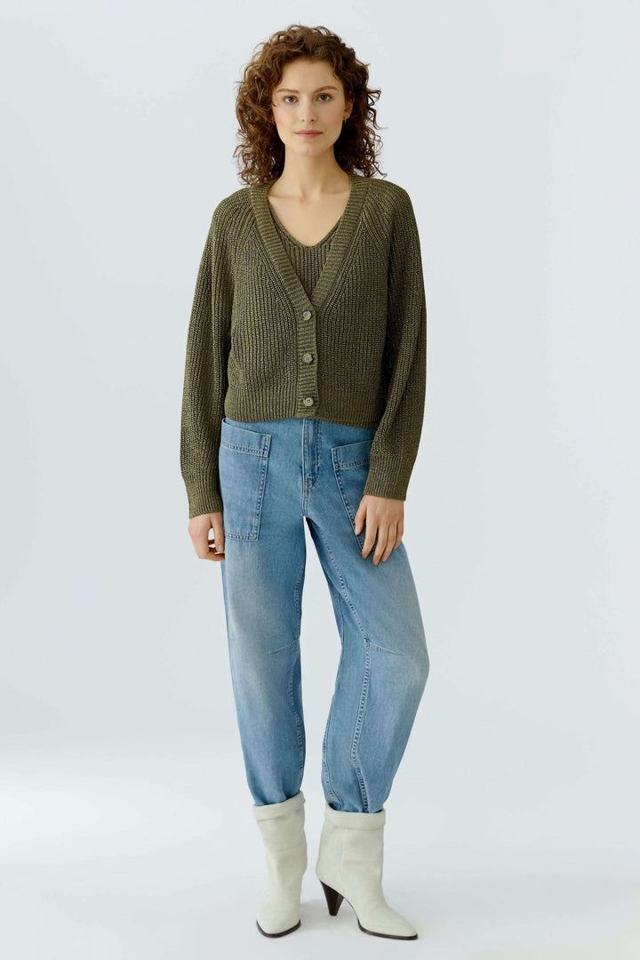 Femme portant un cardigan tricoté court avec encolure en V, boutons classiques, allié au quotidien, style simple et élégant.