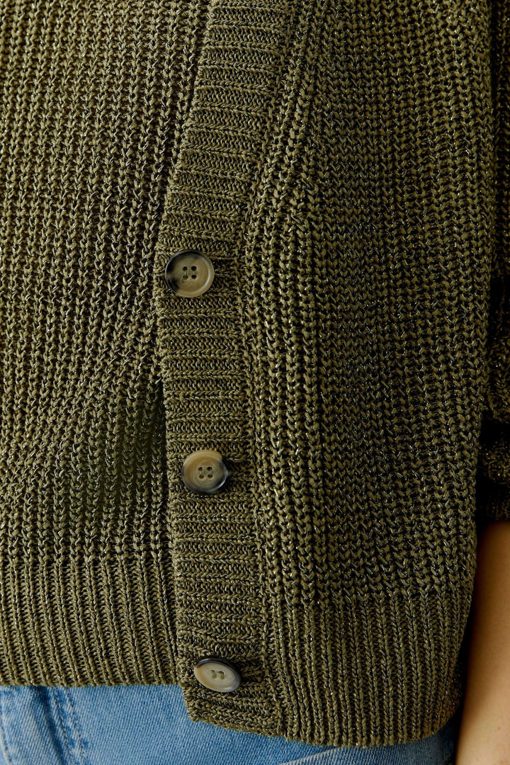 Gros plan sur un cardigan tricoté vert avec fermeture boutonnée, encolure en V, et coupe courte, essentiel du quotidien élégant.