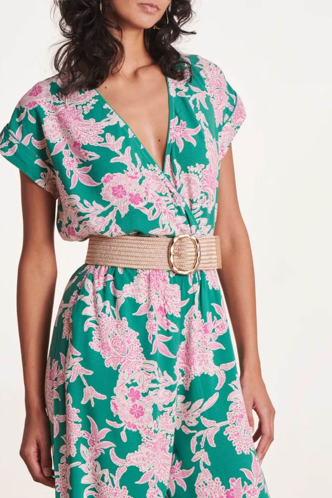 Ceinture large élastique beige avec boucle dorée, portée sur une robe à motifs floraux verts et roses.