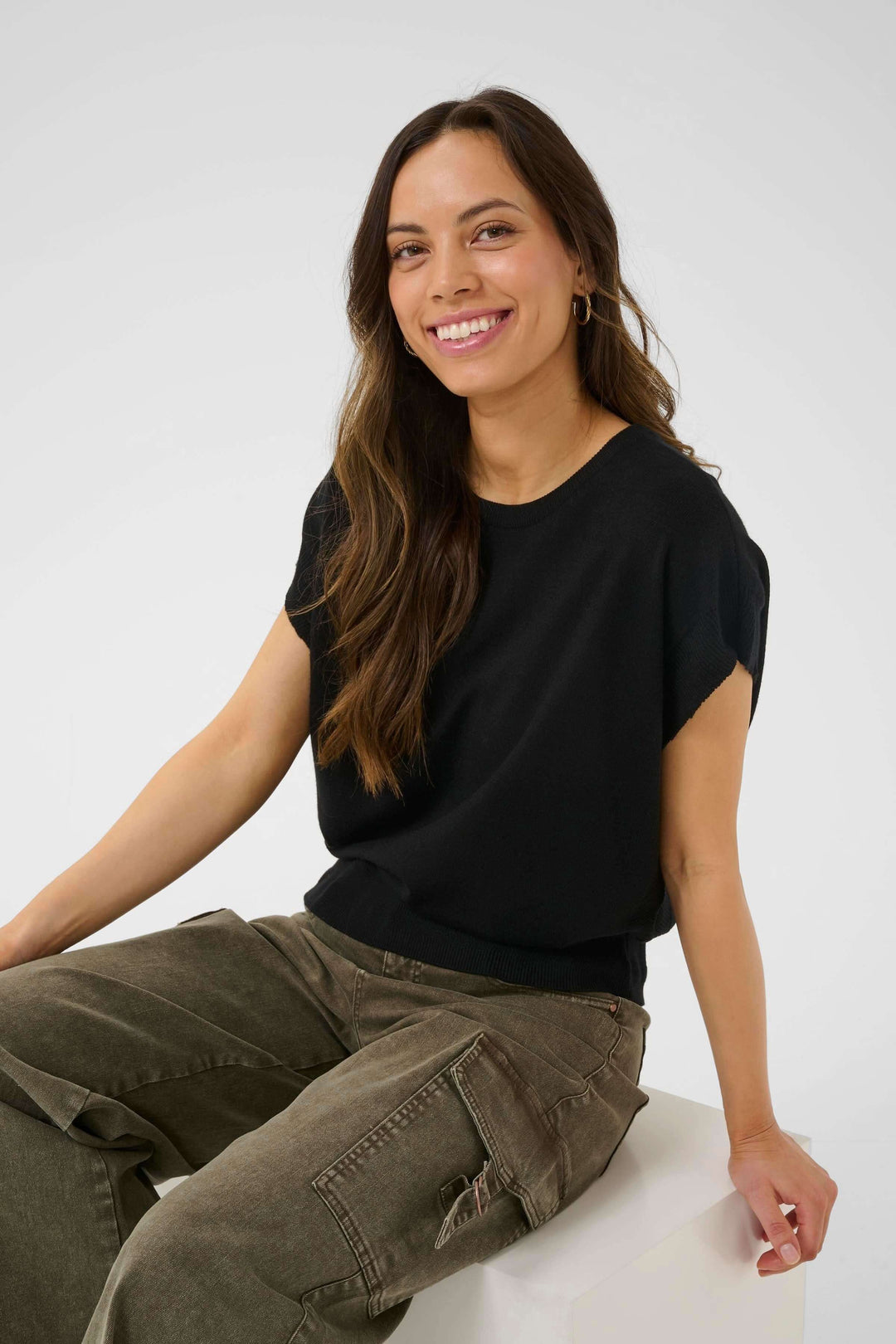 Chandail Dela sans manches, style décontracté, en maille légère, porté par une femme souriante.