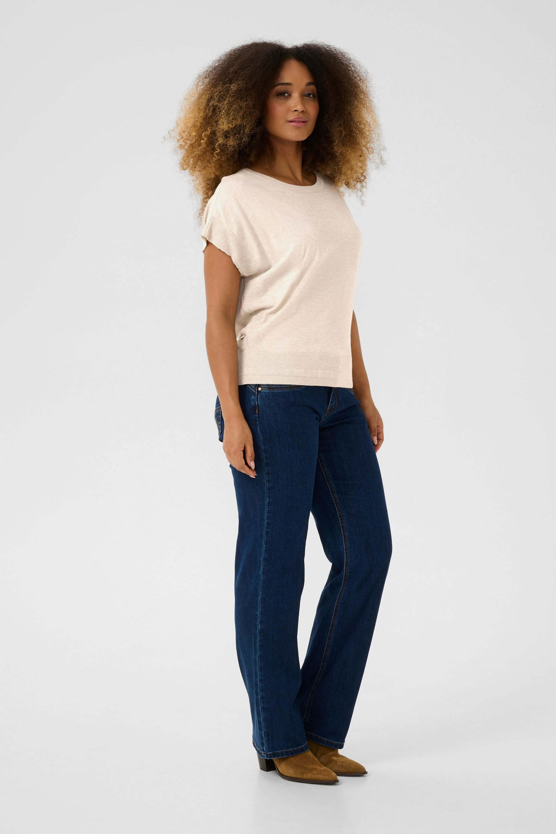 Chandail Dela sans manches, style décontracté, porté avec un jean, silhouette confortable et féminine.