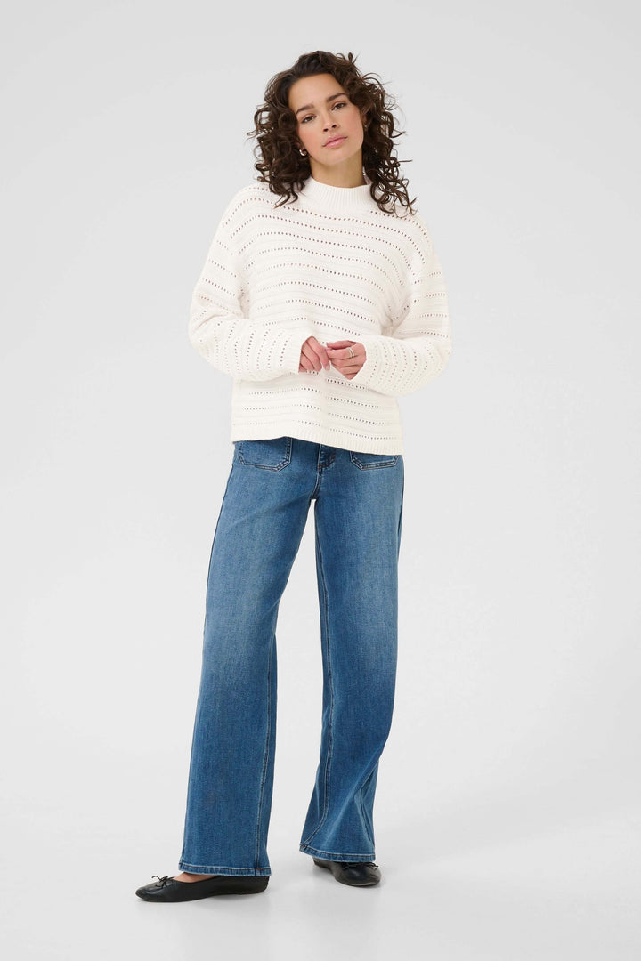 Femme portant Chandail Dolly en tricot ajouré, style moderne et raffiné avec col montant, manches longues, et coupe droite.