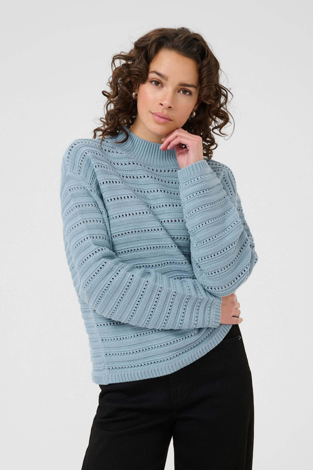 Femme portant le Chandail Dolly en tricot ajouré avec motif subtil et col montant, style moderne et élégant pour look chic.