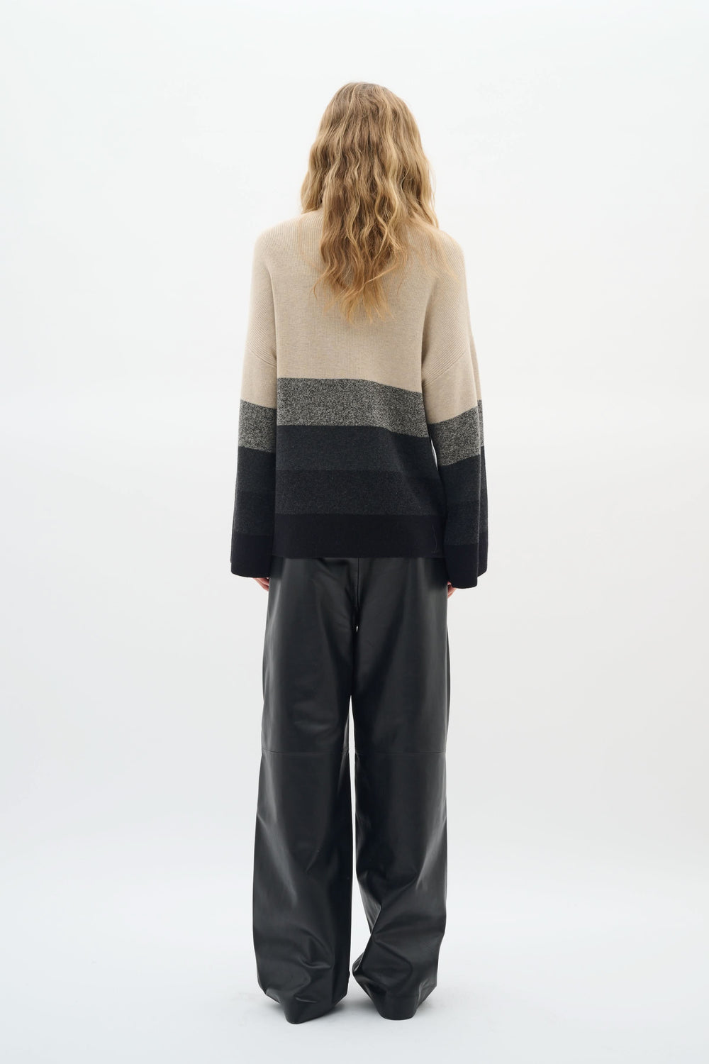 Chandail Gittel à col montant, rayures horizontales modernes, porté avec un pantalon ample, style élégant et cosy.