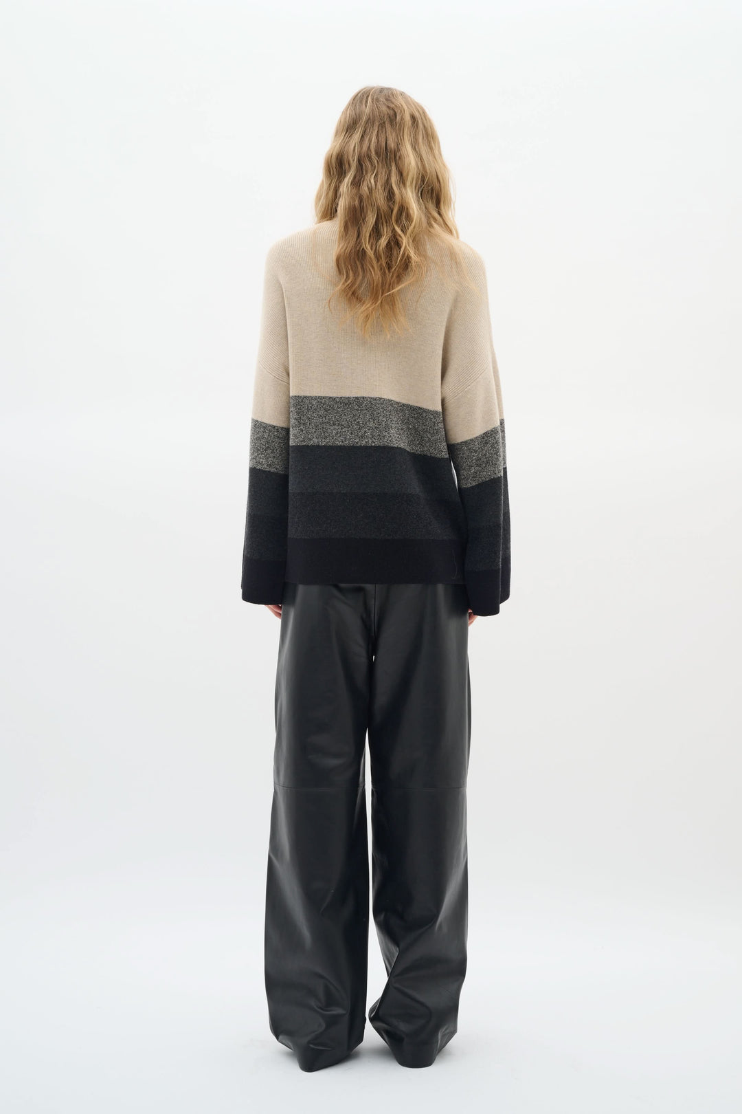 Chandail Gittel à col montant, rayures horizontales modernes, porté avec un pantalon ample, style élégant et cosy.