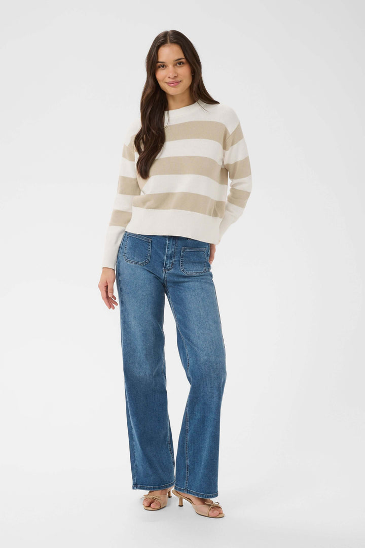 Femme portant le Chandail Harriet en tricot à rayures horizontales, coupe droite et confortable avec manches longues et encolure ronde.