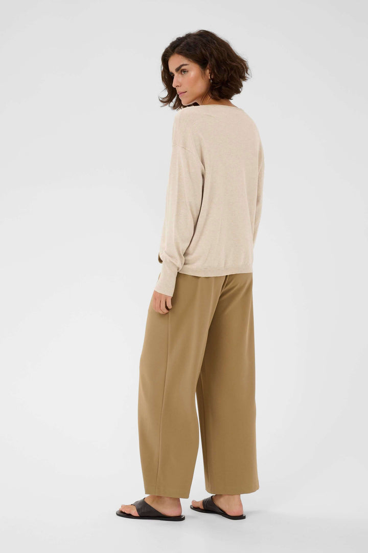 Chandail Lizza ample beige, idéal pour un style décontracté et élégant, porté par une femme. Décris moi le produit en français.