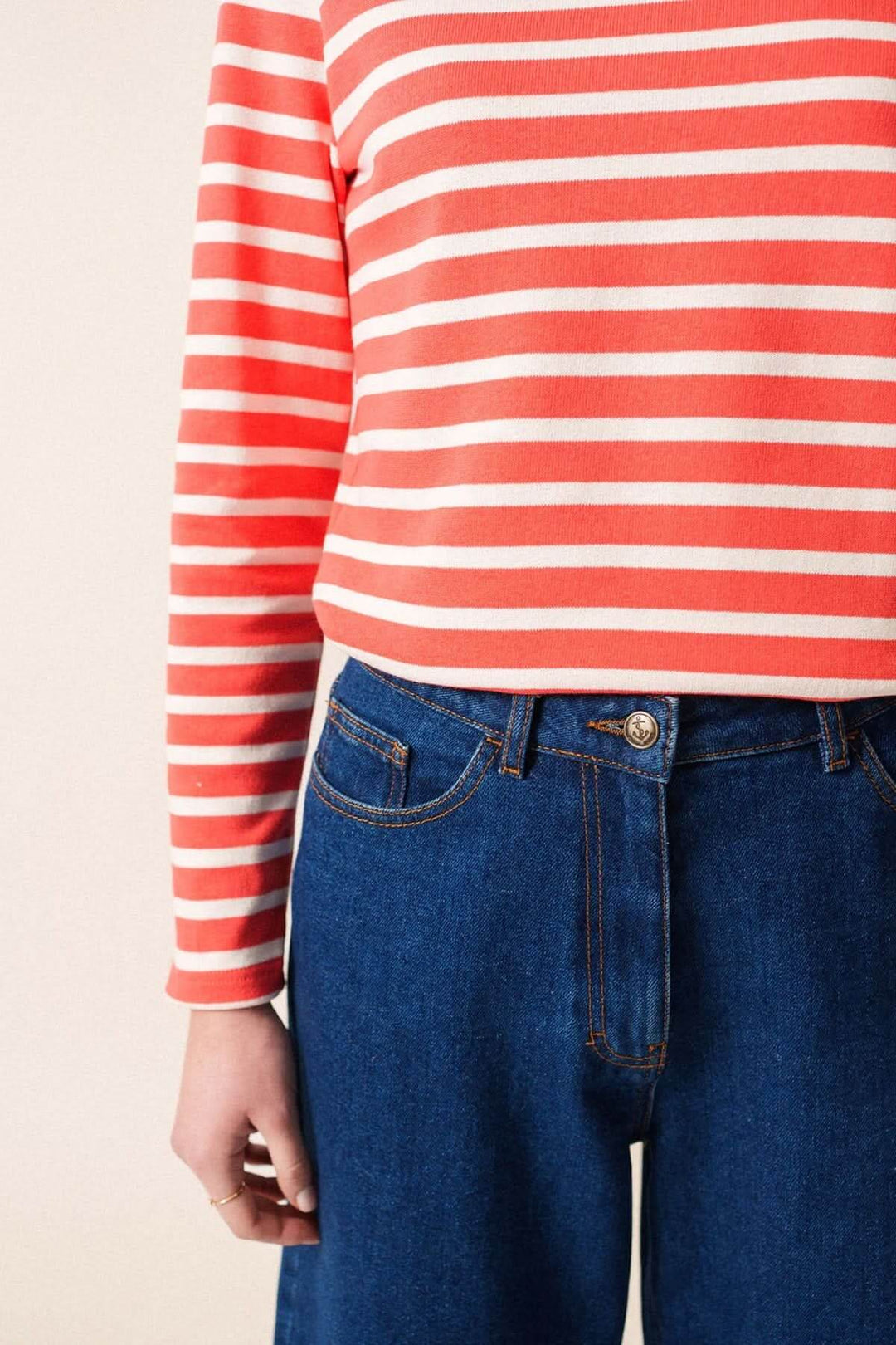 Chandail Méridame II, marinière rayée rouge et blanche, portée avec un jean bleu, style chic et confortable.