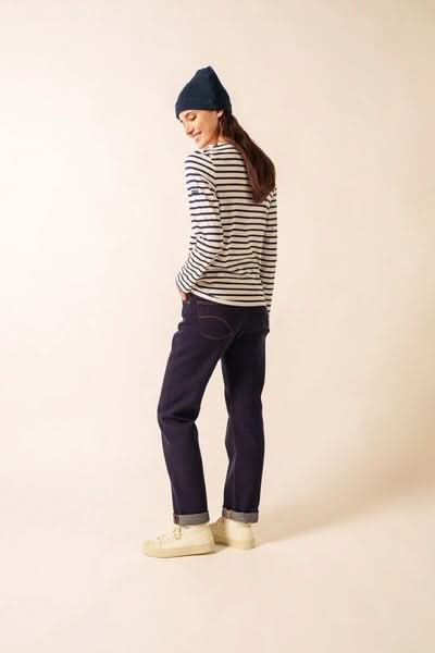 Chandail Minquidame à rayures marines, manches longues et col bateau, porté avec jeans ample pour un look casual-chic.