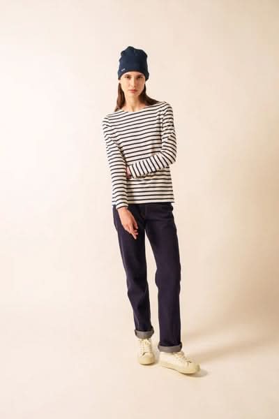 Femme portant un Chandail Minquidame à rayures marines avec pantalon ample, style casual-chic, en coton doux, encolure bateau, manches longues.