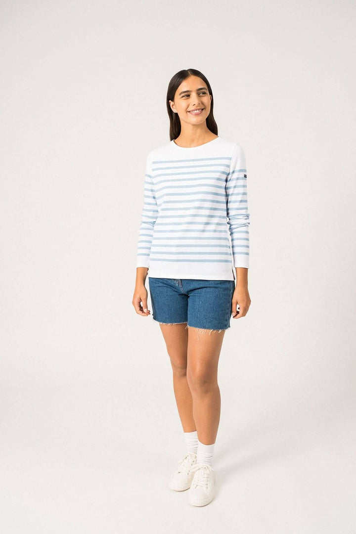 Chandail naval féminin à rayures bleues, coupe ajustée, manches longues, porté avec un short en jean.