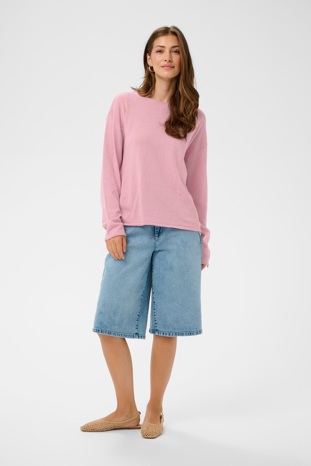 Femme portant Chandail Romane rose à manches longues avec encolure bateau et coupe décontractée, assorti à un short en jean.