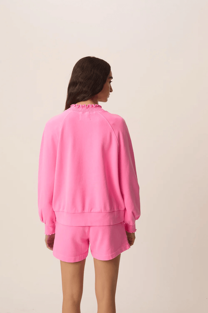 Femme portant le Chandail Yaelle ouaté court à manches longues coupe ample en rose, vue de dos, avec short assorti.